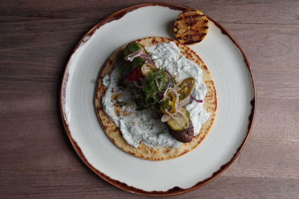 Kofta flatbread with dill and mint yogurt, pickles and charred lemon