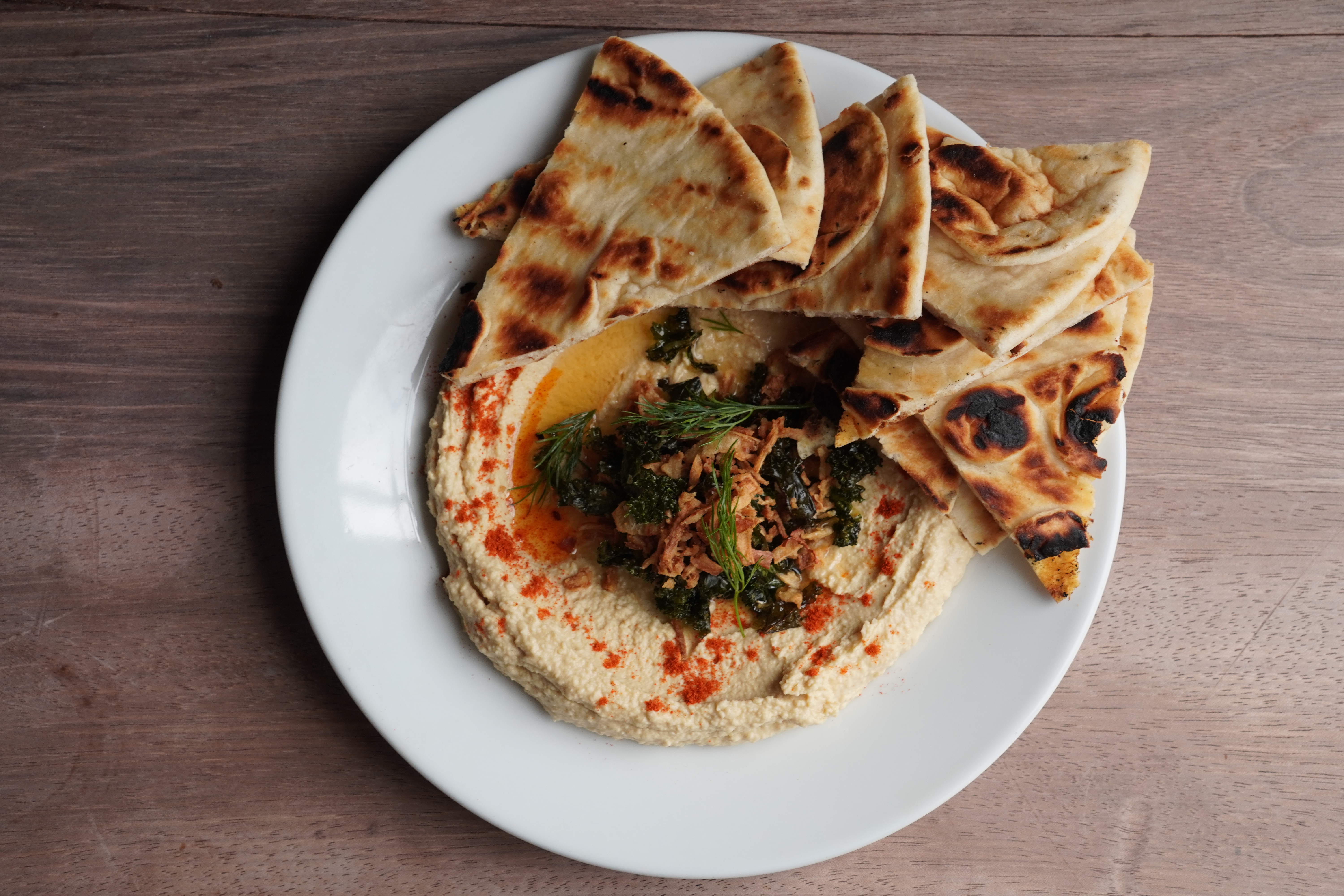 Fire-cooked dish served on warm flatbread with smoke and herbs